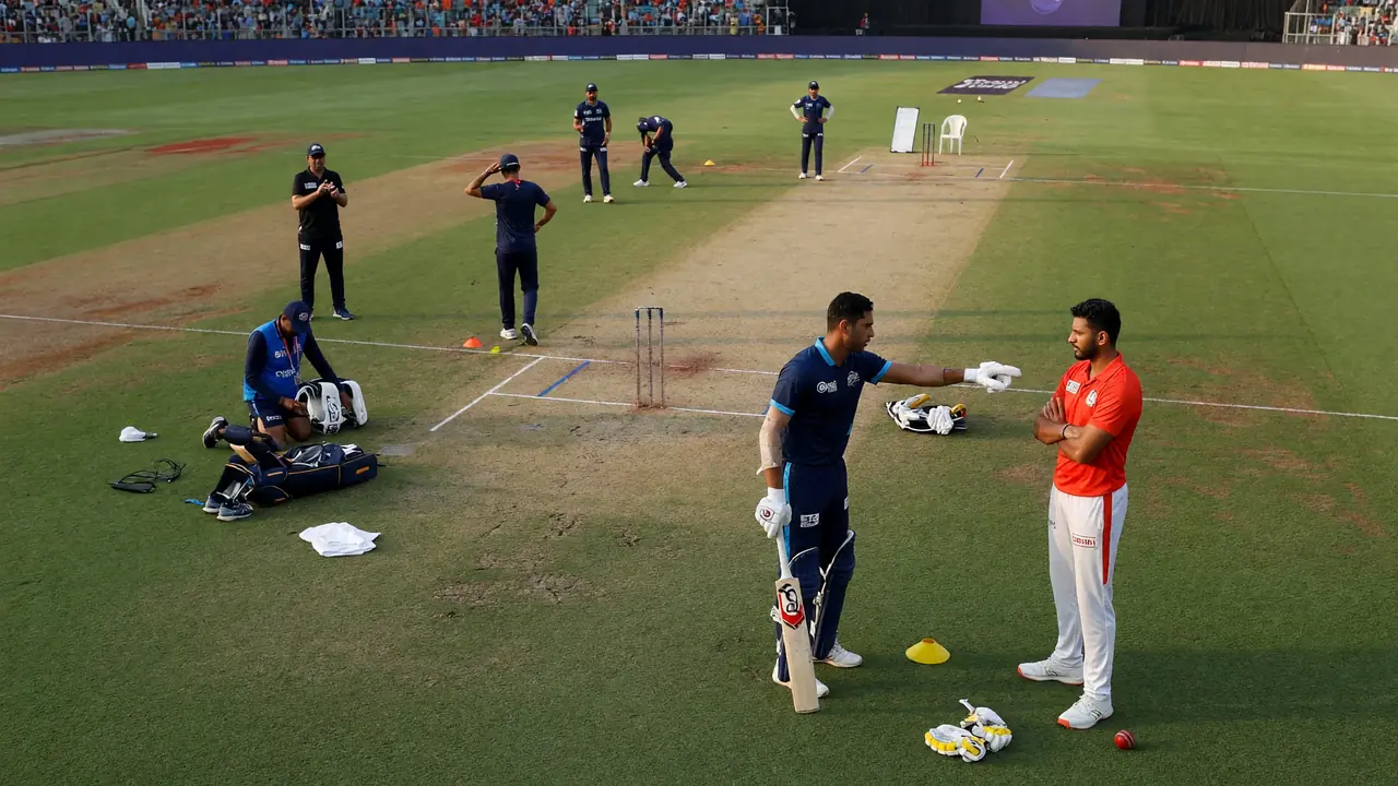 Two cricket players in coloured training kits discussing field placements near the pitch with stumps and cones in the foreground